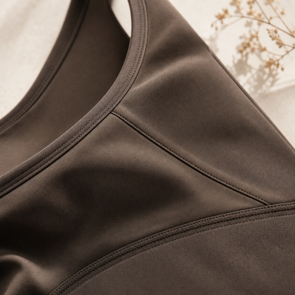 Close detail of espresso TRILUME activewear seams and support panel